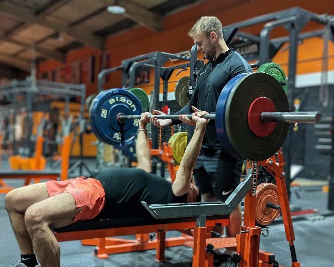 Chris helping a client with a bench press