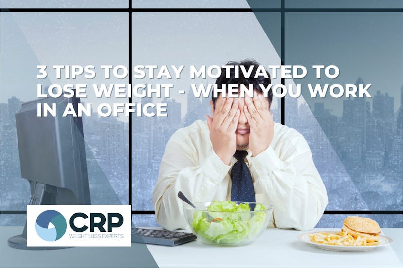 Photo of an office worker with his head in his hand sat at his desk. To his right is his computer, in front of him is a salad and to his left is a burger and fries. The caption reads "3 tips to stay motivated to lose weight when you work in an office"